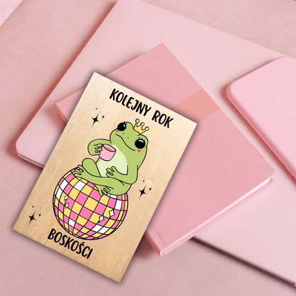 kartka urodzinowa dla przyjaciółki z motywem żaby w koronie i napisem kolejny rok boskości
