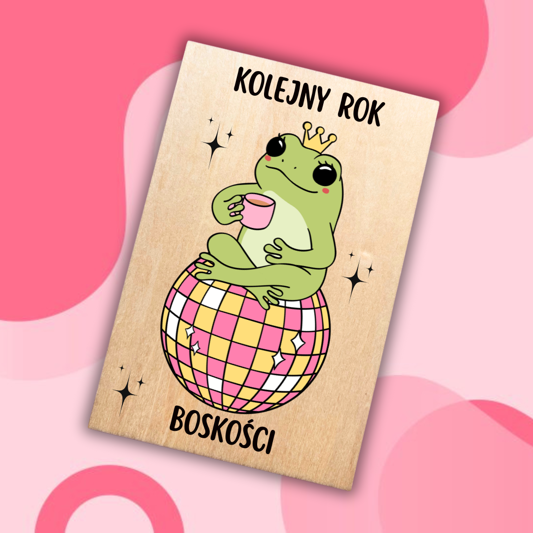 drewniana kartka urodzinowa z żabą w koronie siedzącą na kuli dyskotekowej 